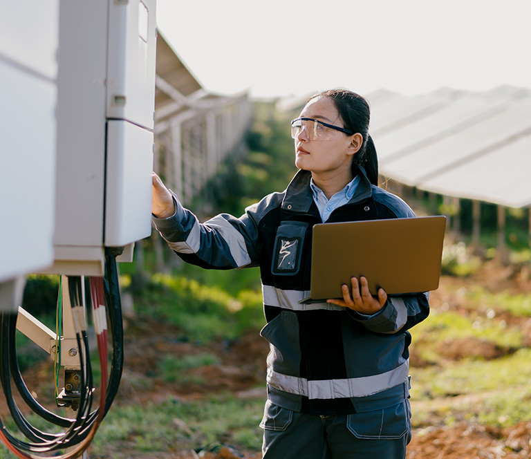 Asian female engineer working at solar power station.