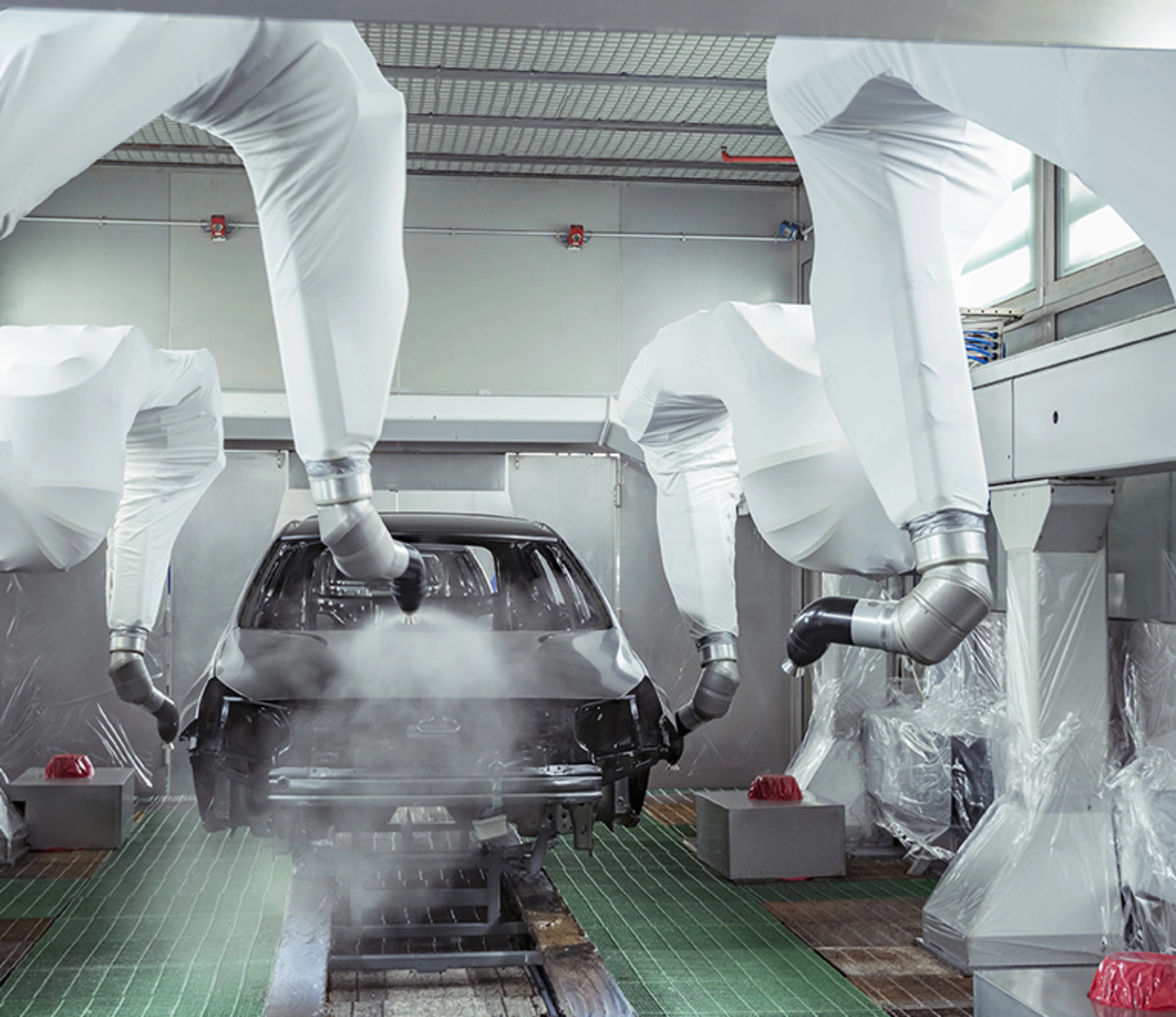 Robot paint spraying car bodies in car factory.
