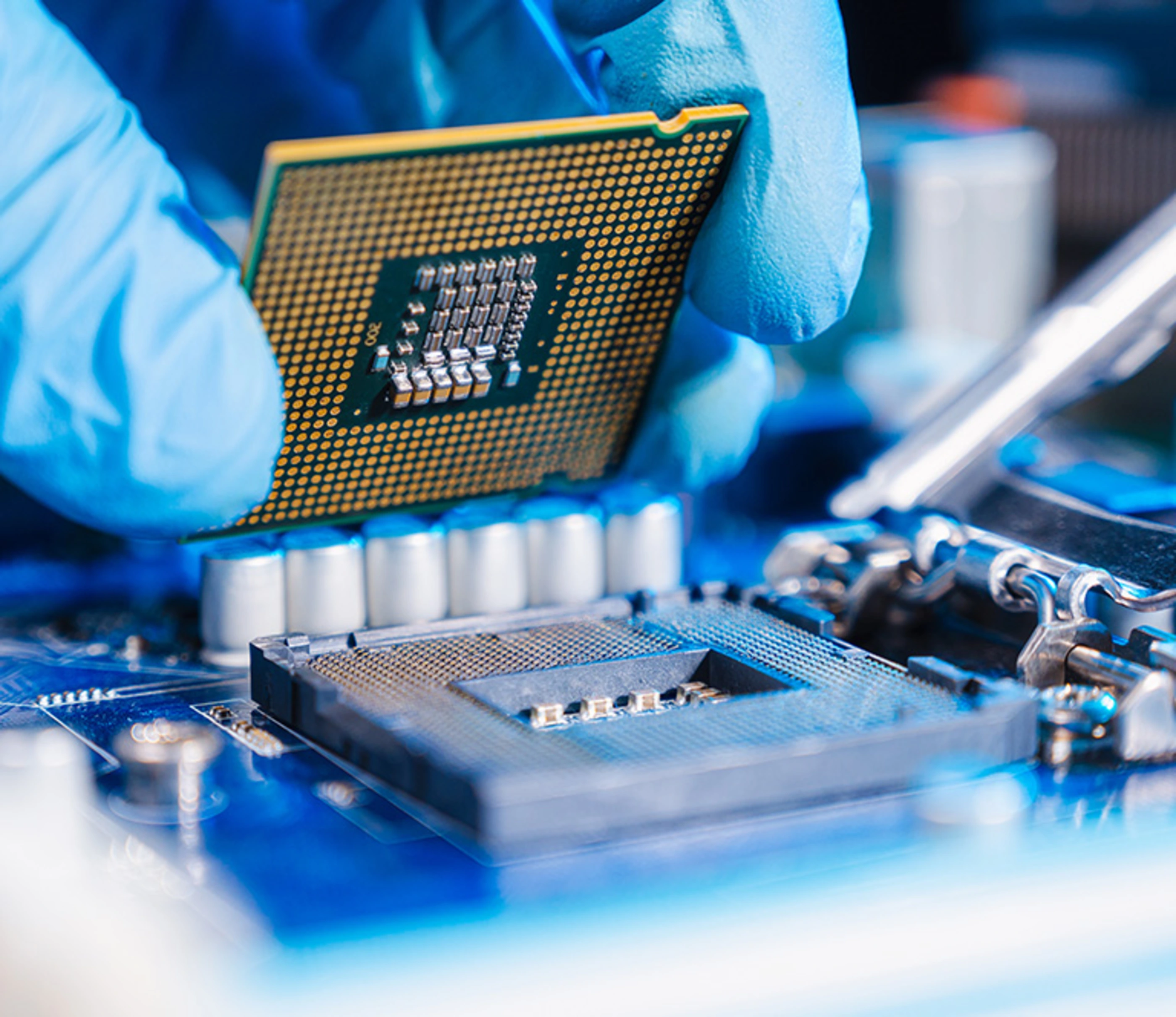 The technician laying CPU in the motherboard socket.