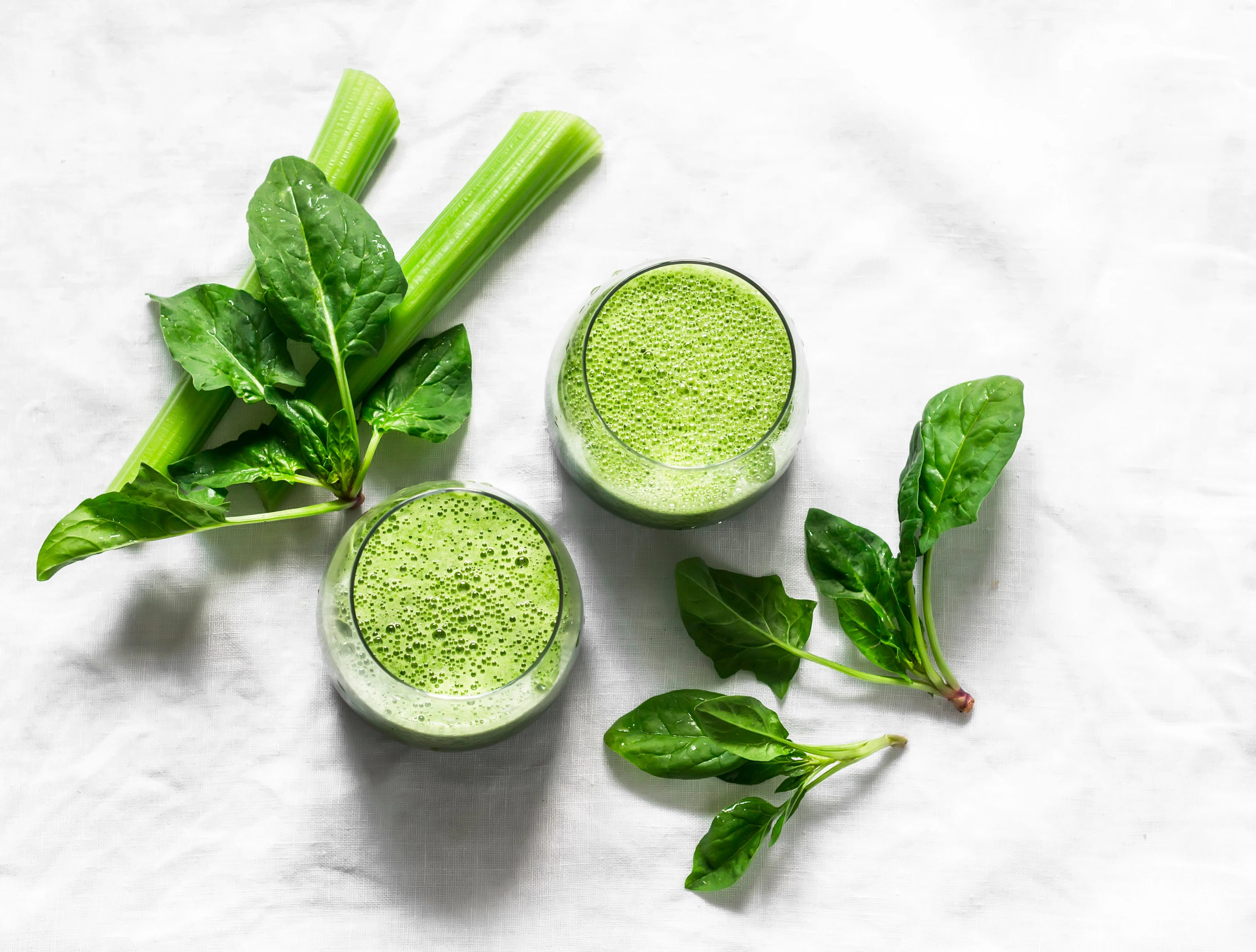 Detox diet food vegetarian concept.  Freshness celery, spinach, natural orange juice green smoothies on a light background, top view. Copy space, flat lay    ; Shutterstock ID 1756521119; purchase_order: nfi; job: ; client: ; other: 