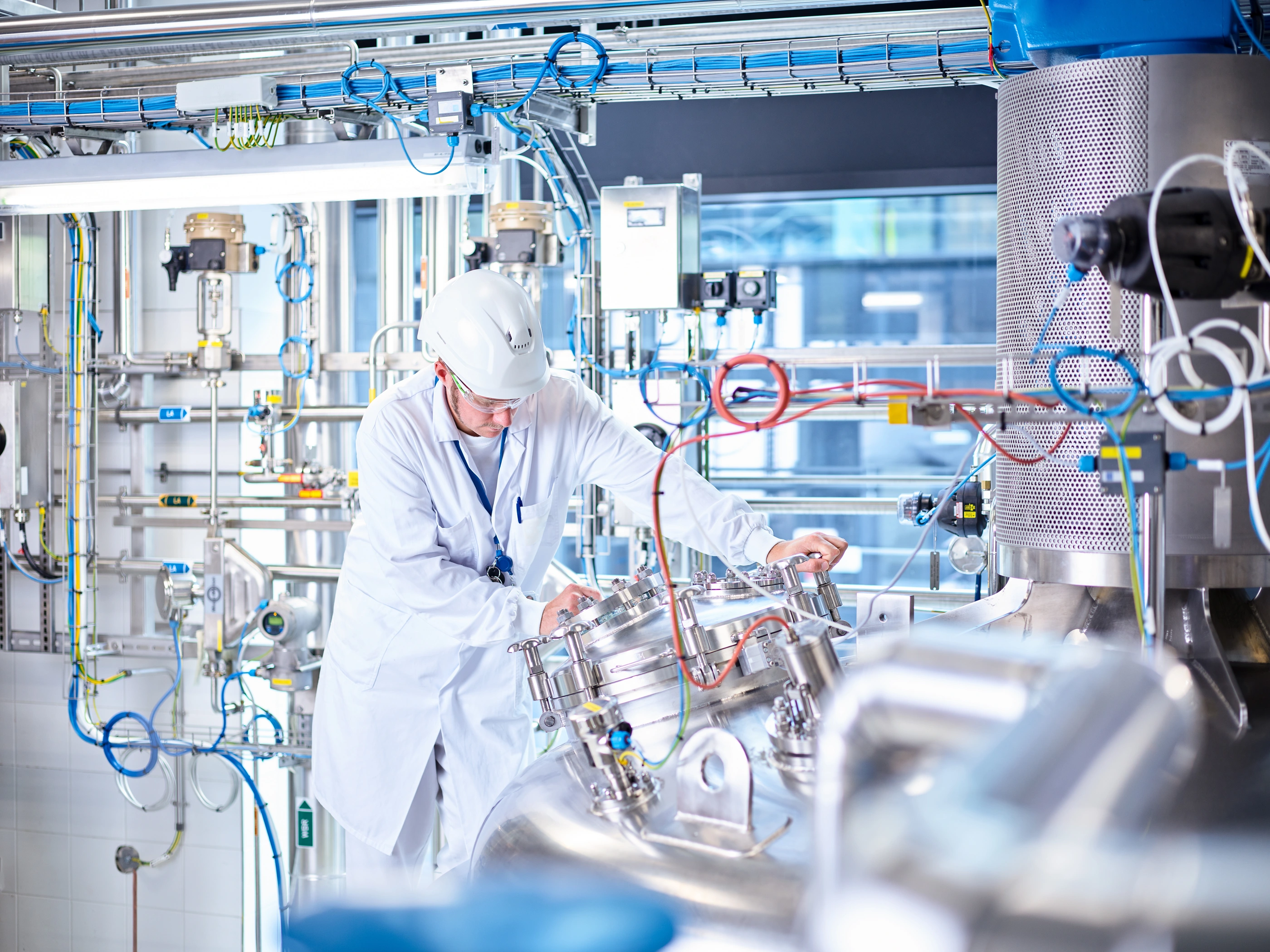 Chemist with helmet in chemical laboratory.