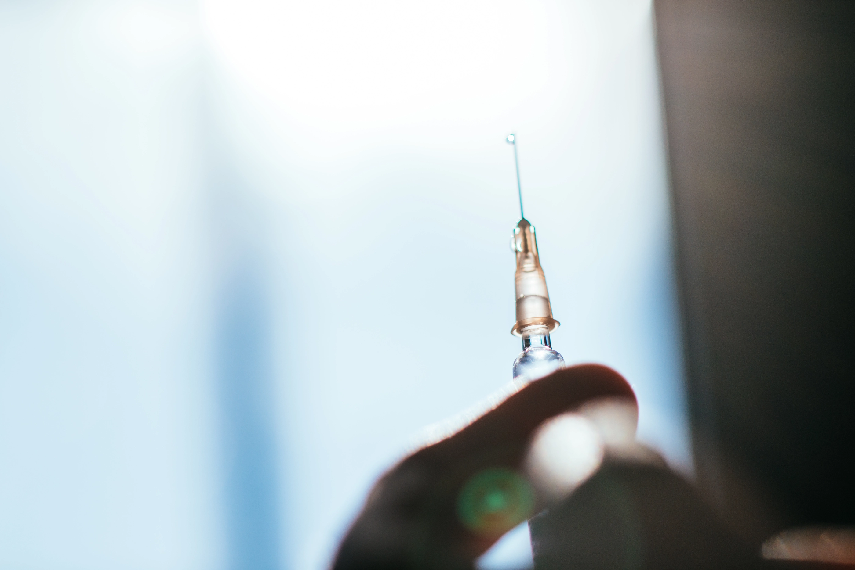 Woman preparing an injection at home in backlight.