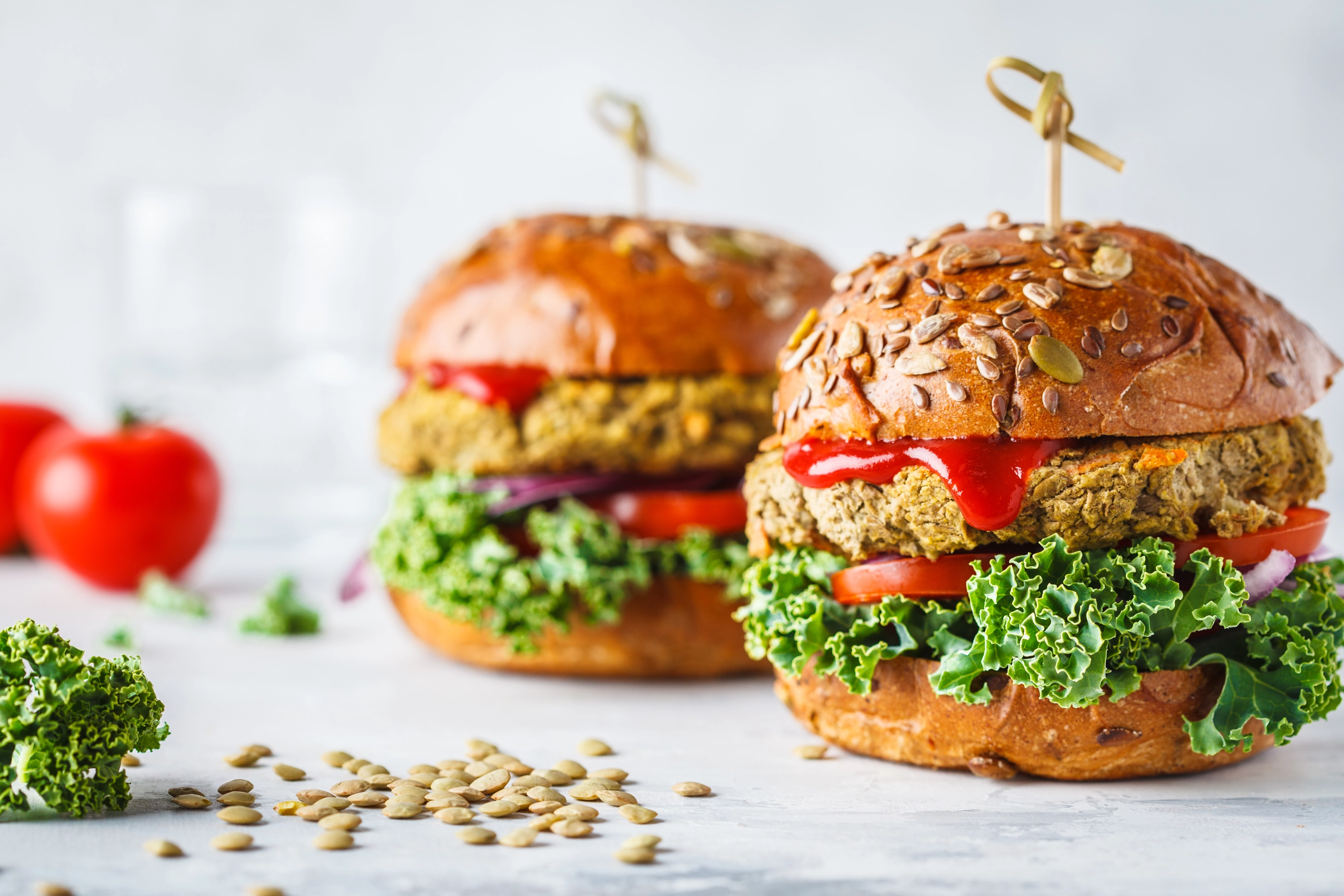 Vegan lentil burgers with kale and tomato sauce on a white background. Plant based food concept.; Shutterstock ID 1239647566; purchase_order: NFI; job: ; client: ; other: 