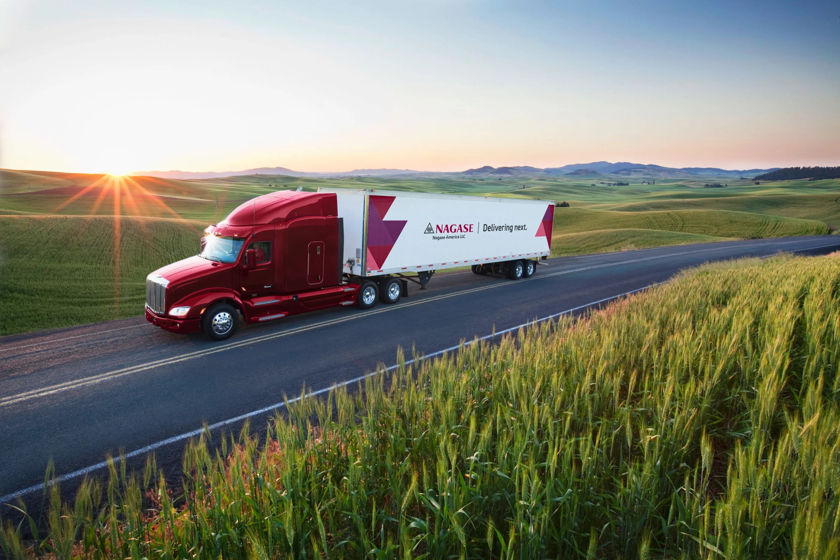 Nagase branded truck on a road surrounded by green fields