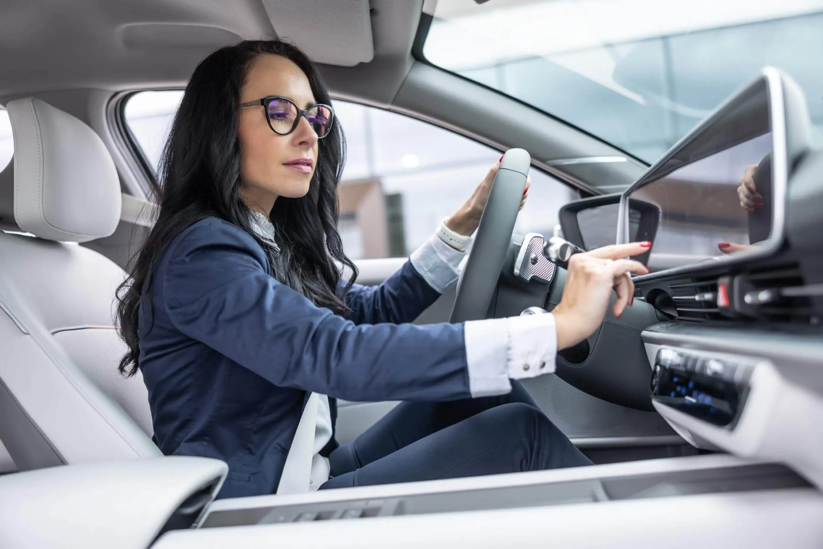 Woman driving car using touch screen