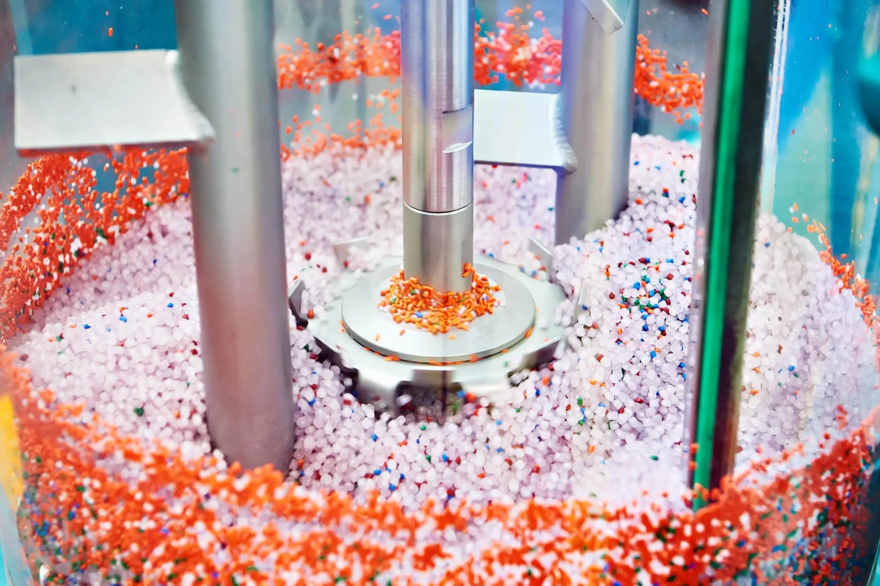 orange and white polymer pellets in machine