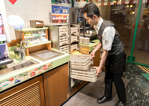 Saizeriya employee stacking Tritan cups behind the bar