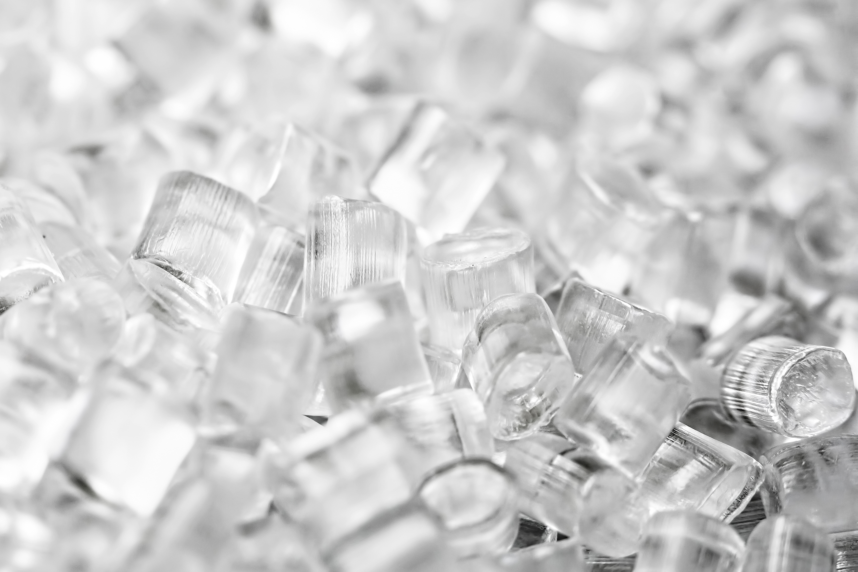 1047510530 Transparent Plastic in granules. Polymer pellets. Isolated on a black background.
